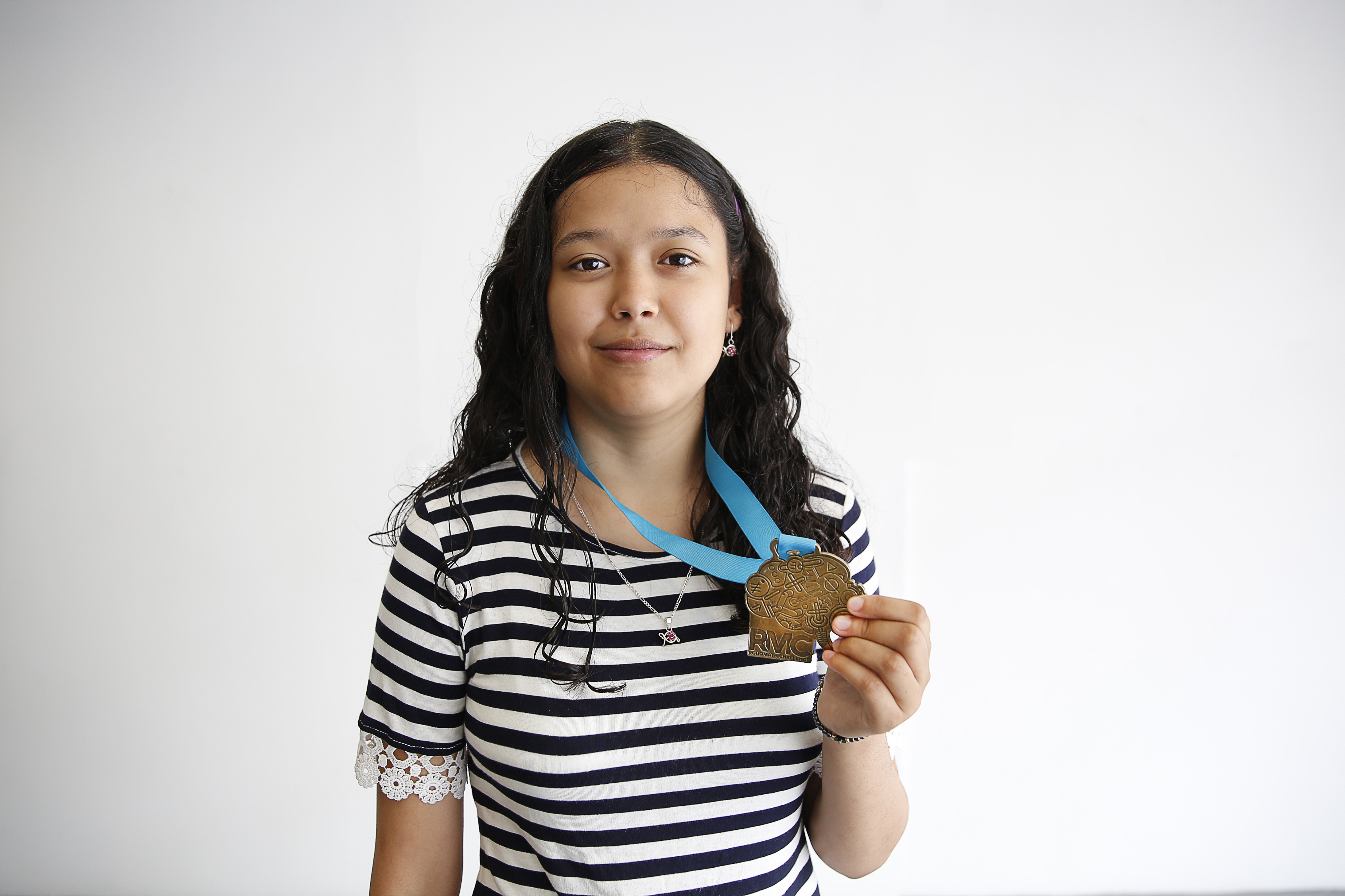 Alumna con medalla de primer lugar que obtuvo en competencia