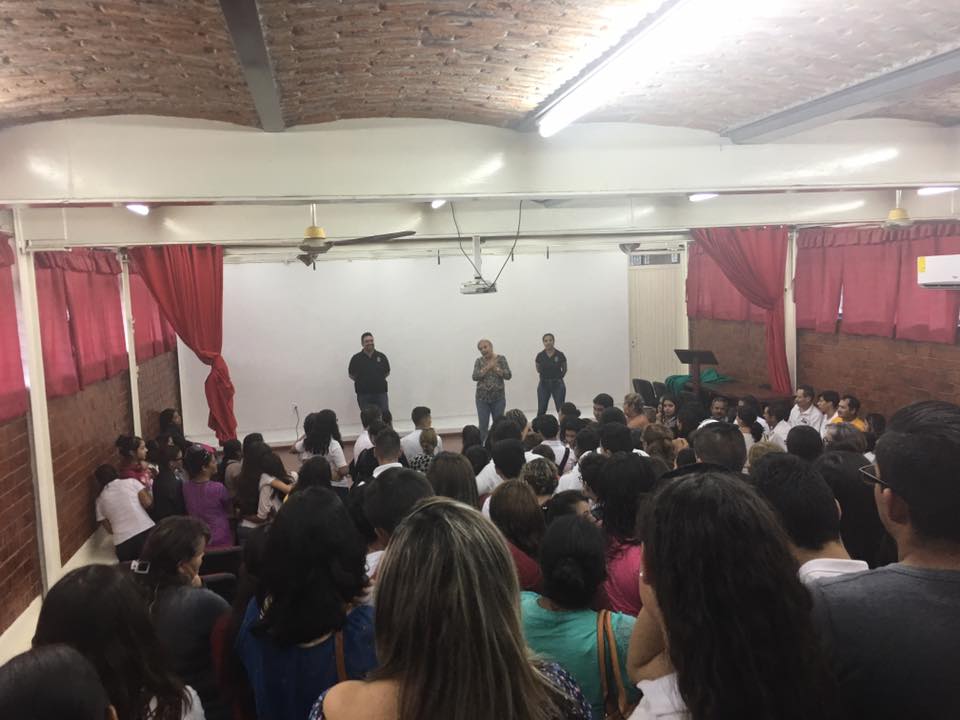 Integrantes de la Coordinación de Seguridad Universitaria en auditorio frente a estudiantes