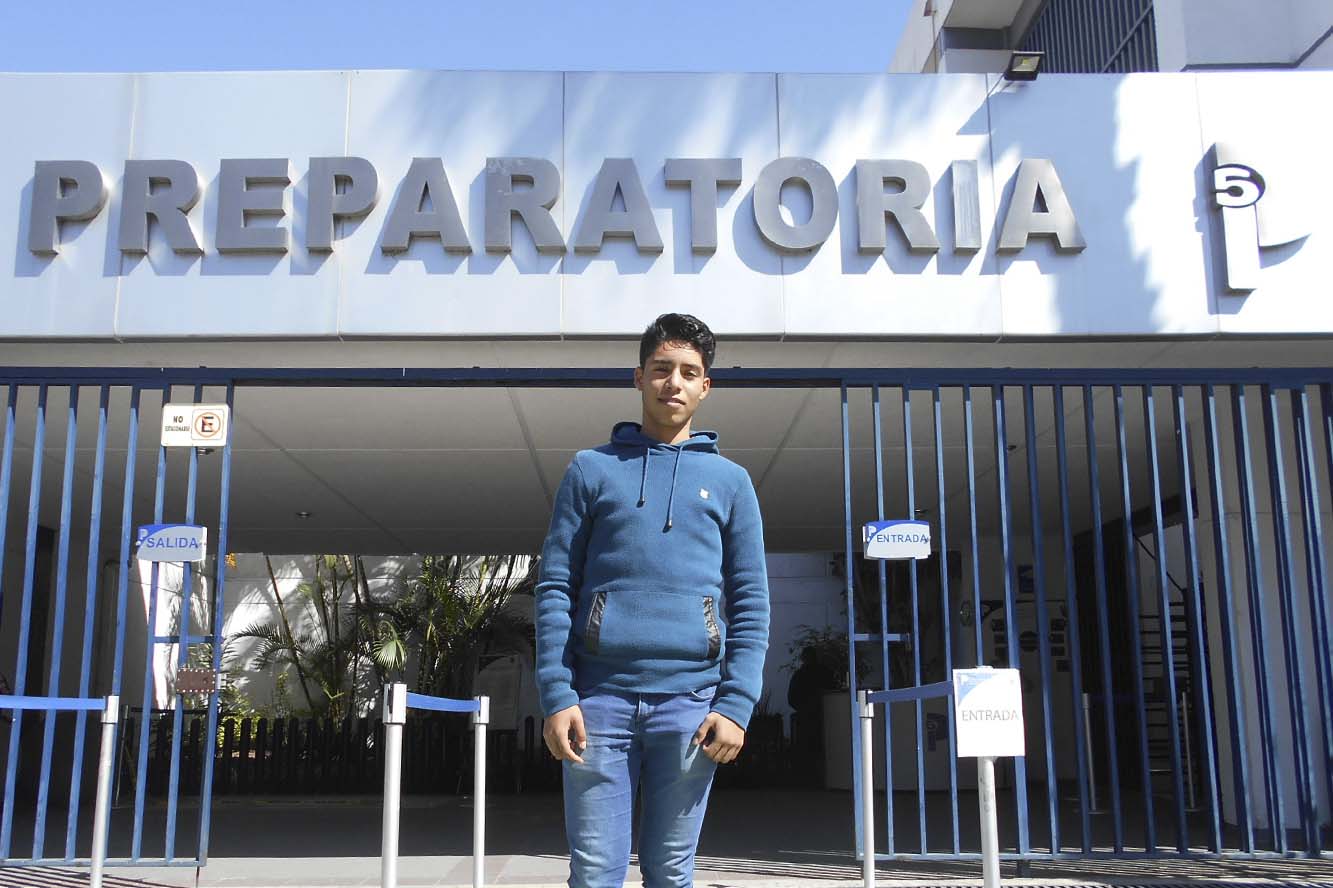 Alumno frente a entrada del plantel