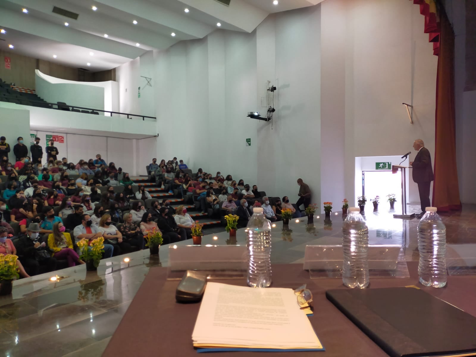 maestro José Trinidad Padilla López en pódium frente a asistentes en el auditorio