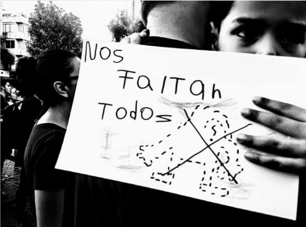 Personas se abrazan y una sostiene letrero nos faltan todos