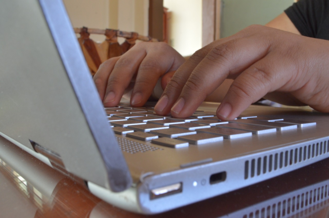 Manos escribe en laptop