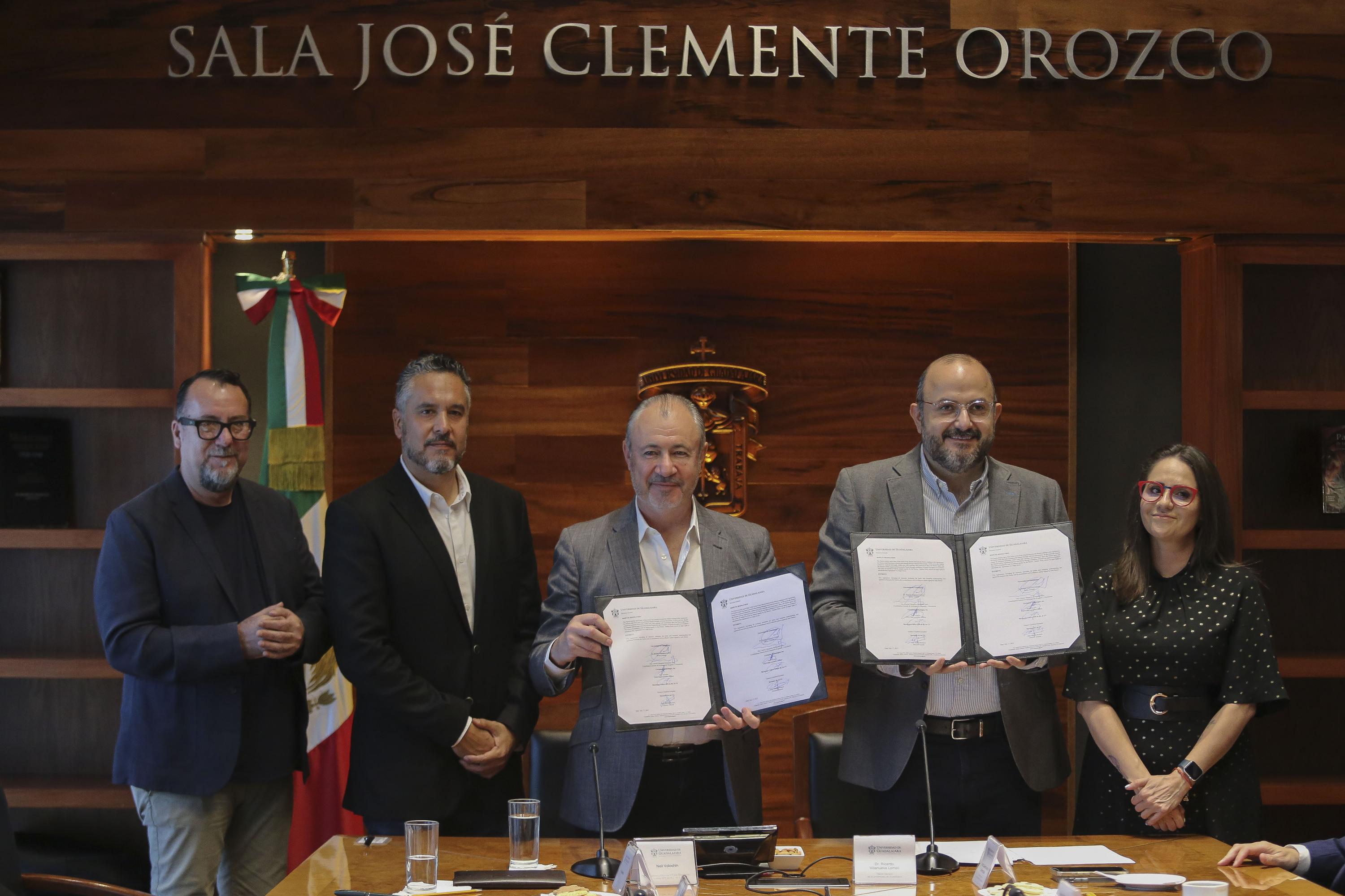 Autoridades del evento en sala de reunión mostrando los documentos del acuerdo