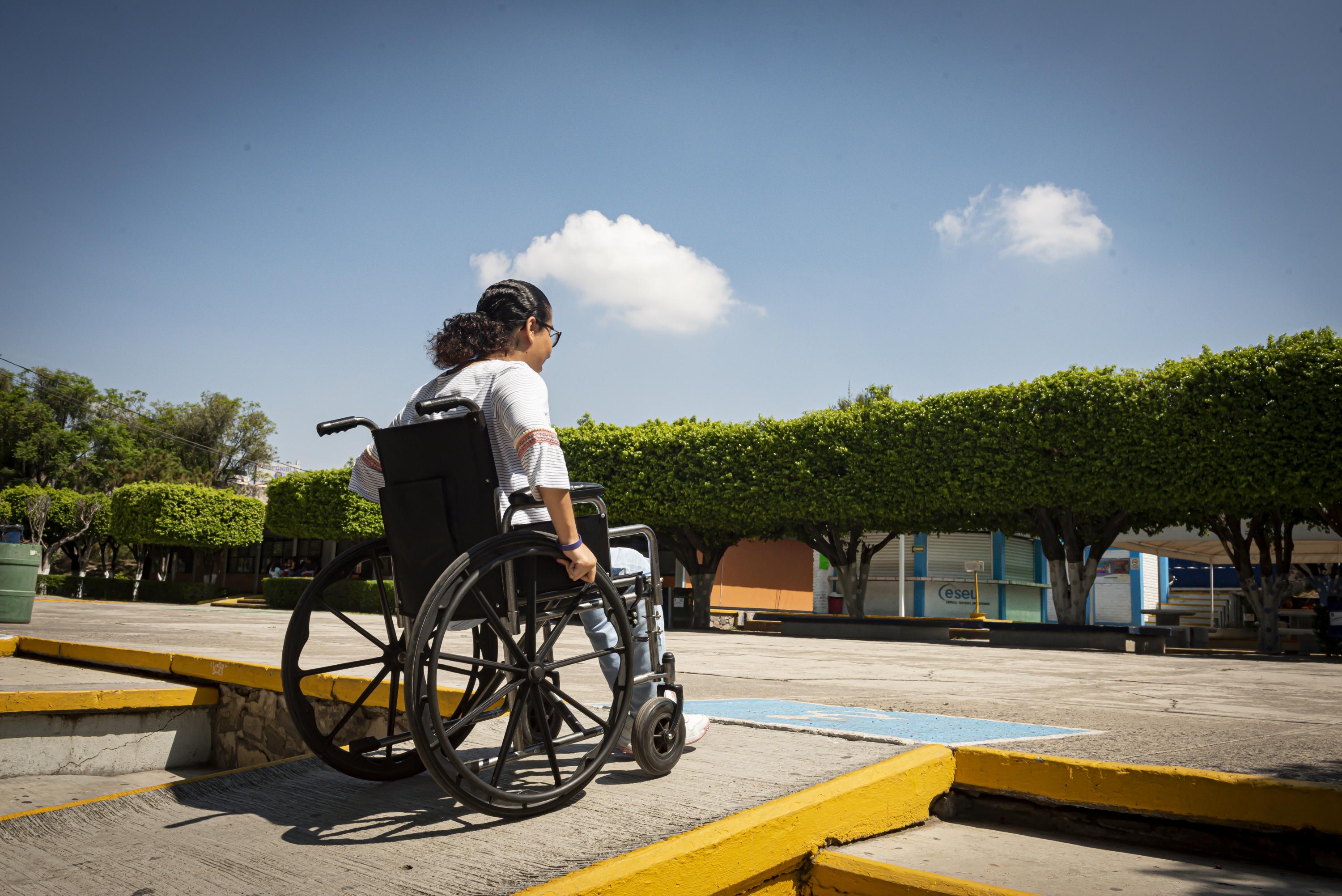 persona en silla de ruedas usa rampa de acceso para discapacitados