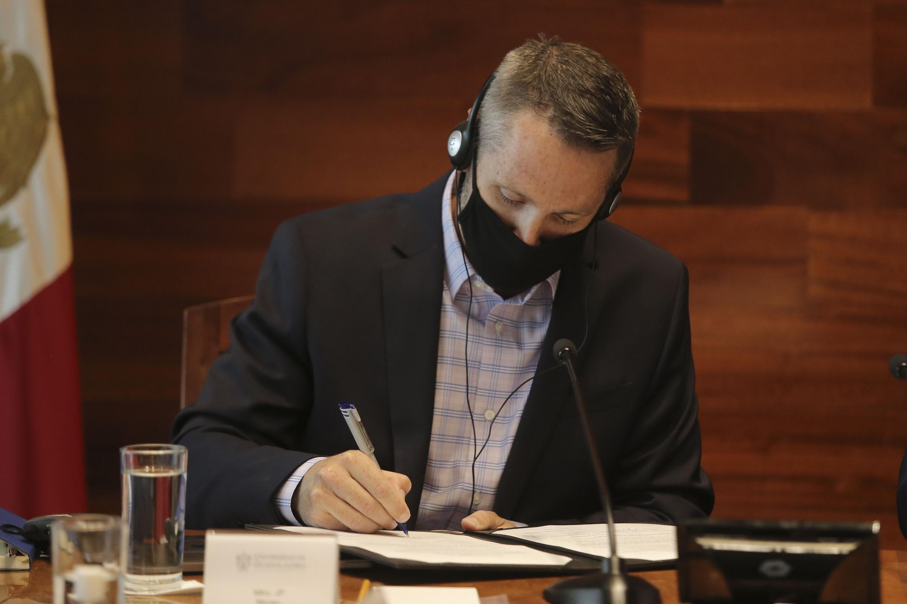 Autoridades del evento en firma de documento
