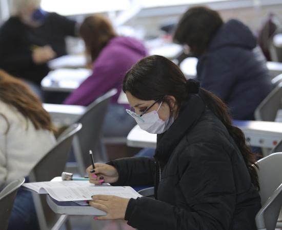 Miujer realiza examen en aula