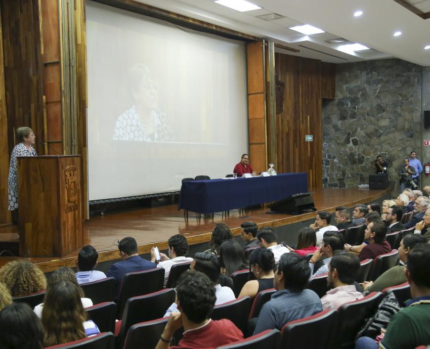 Autoridades del evento junto a asistentes en auditorio