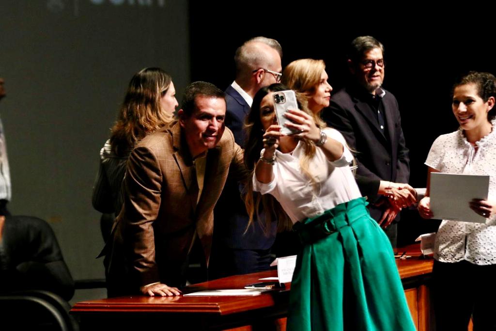 Autoridades del evento en presidium entregando documentos de nombramiento