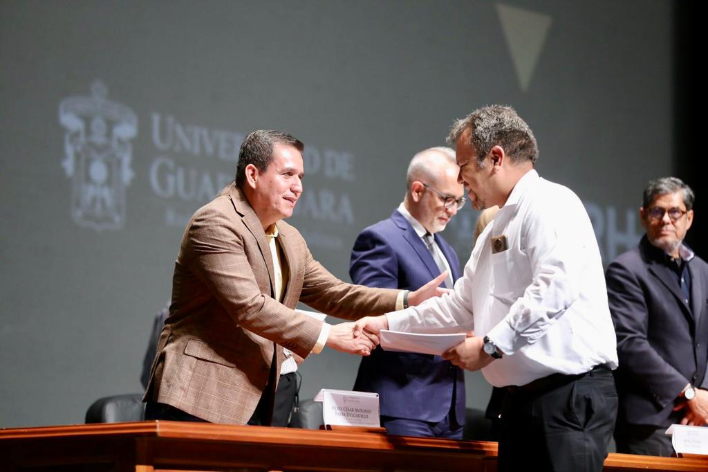 Autoridades del evento en presidium entregando documentos de nombramiento