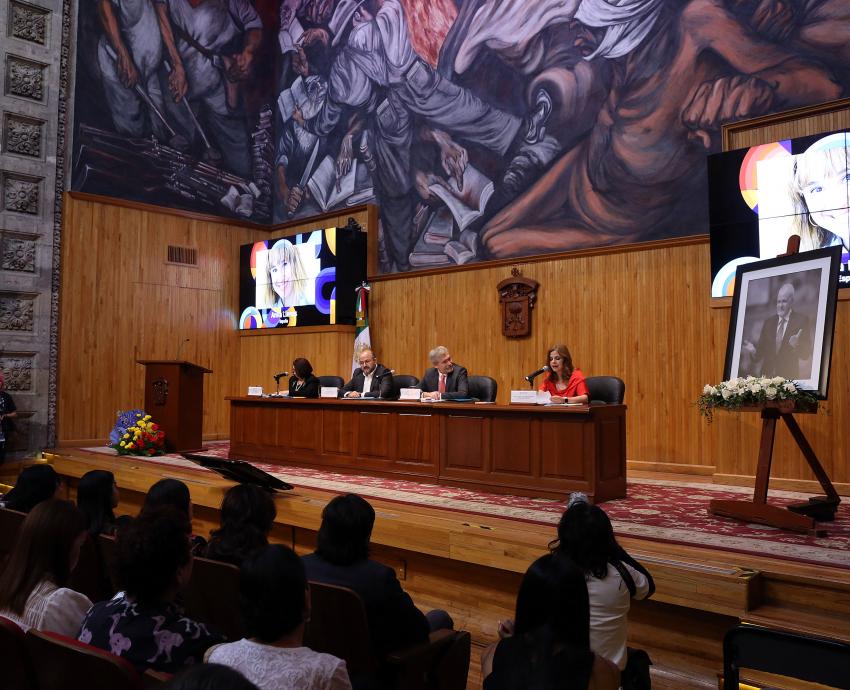 Autoridades del evento en presidium frente a asistentes en auditorio