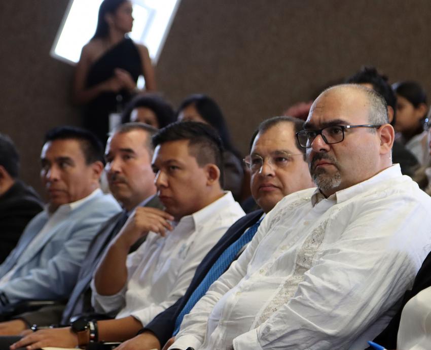 asistentes al evento sentados en auditorio