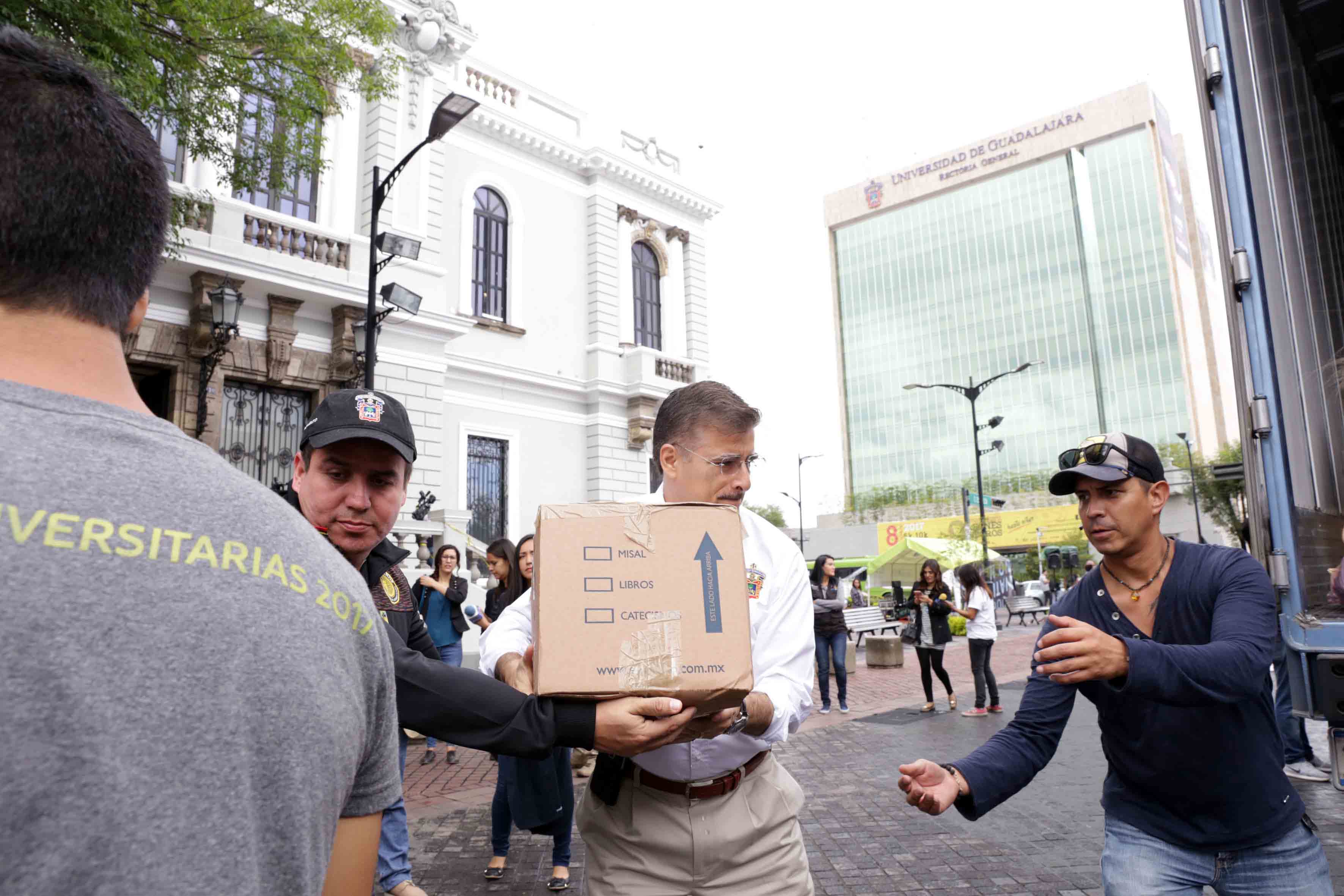 Rector general con ayuda de voluntariado carga camión con víveres