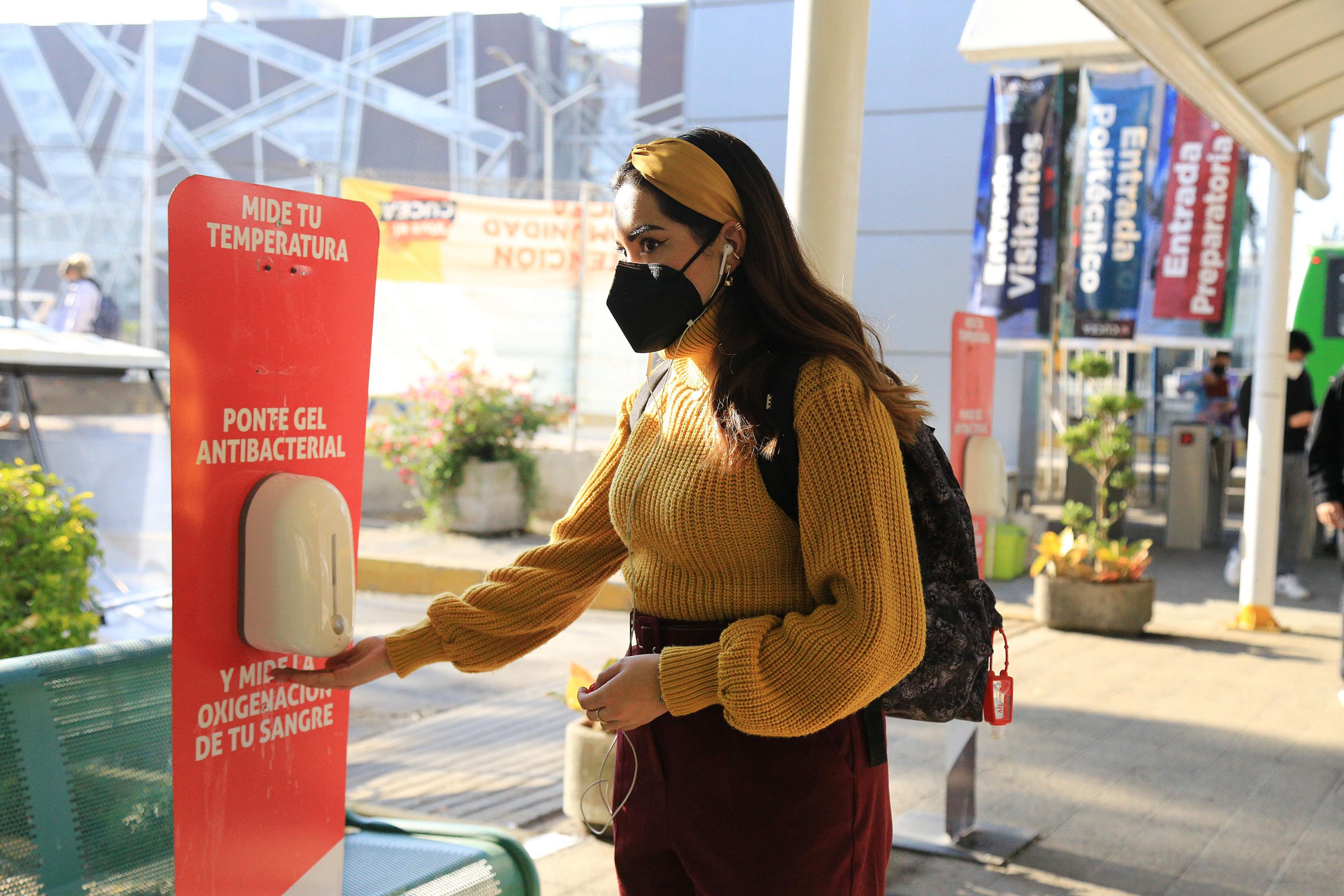 Alumna toma gel antibacterial para desinfectar sus manos