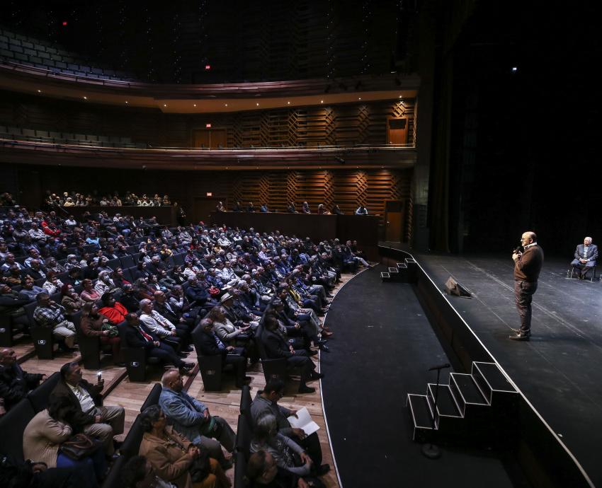 Personas asistentes al evento sentadas en auditorio