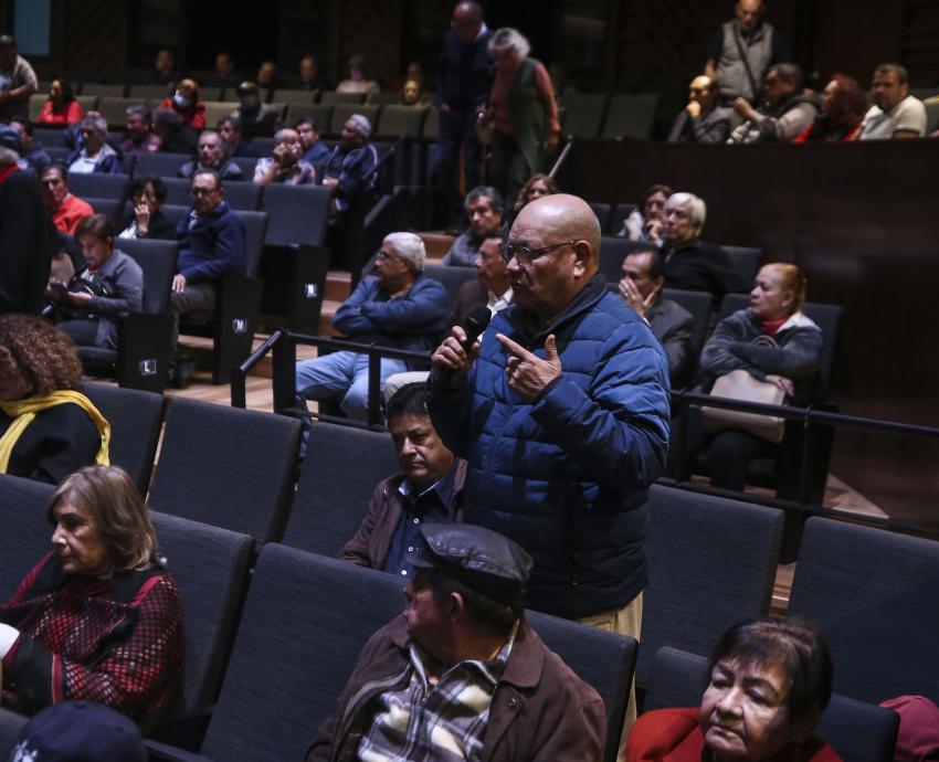 Personas asistentes al evento sentadas en auditorio