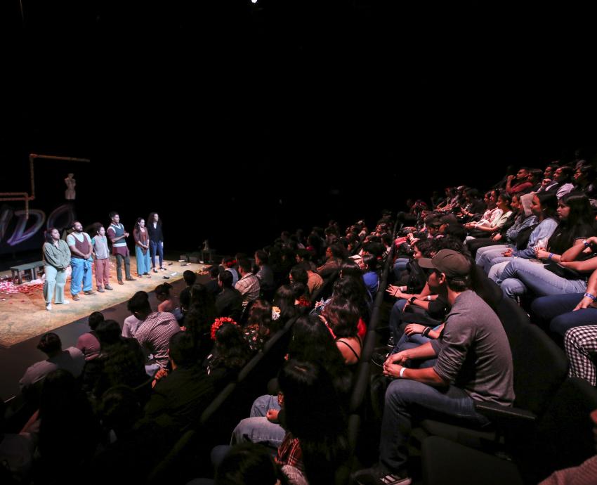 Grupo de participantes en concurso frente a asistentes en auditorio