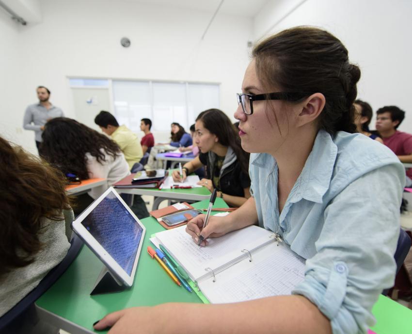 grupo de jóvenes sentados en aula escribiendo