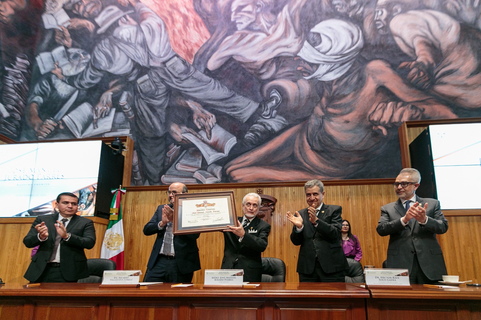 Autoridades del evento de pie en presidium junto al homenajeado