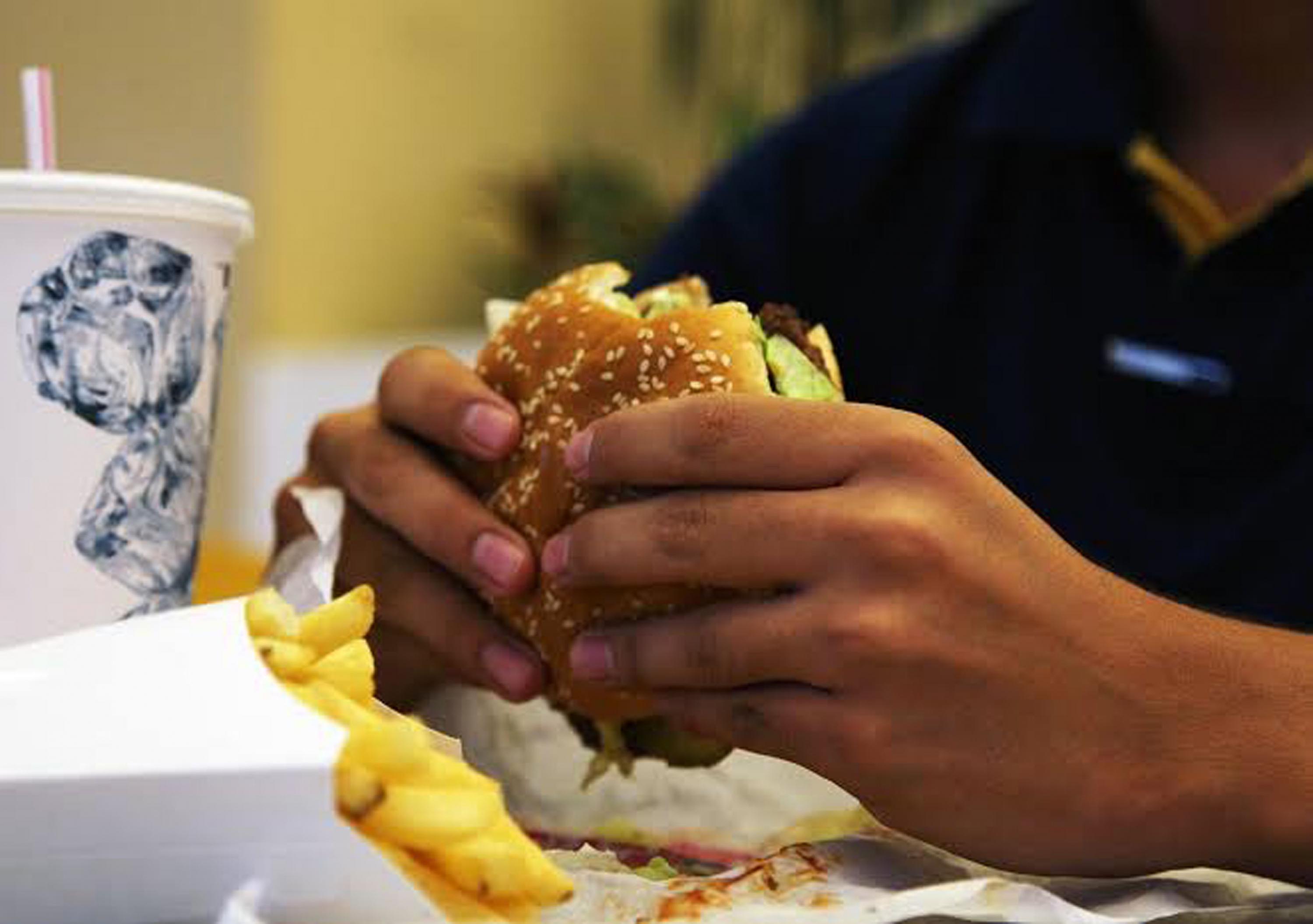 Manos sontiene una hamburguesa