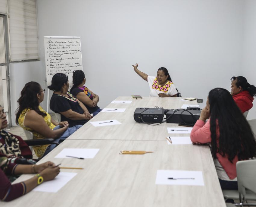 grupo de mujeres indígenas sentadas reunidas en sala de junta