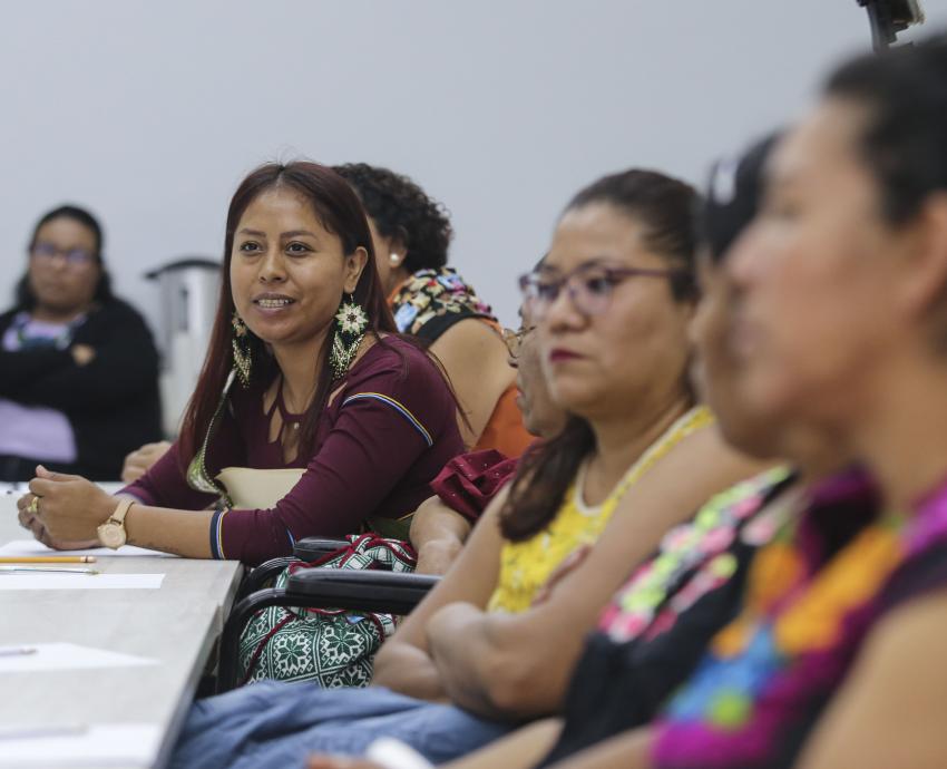 grupo de mujeres indígenas sentadas participan en reunión