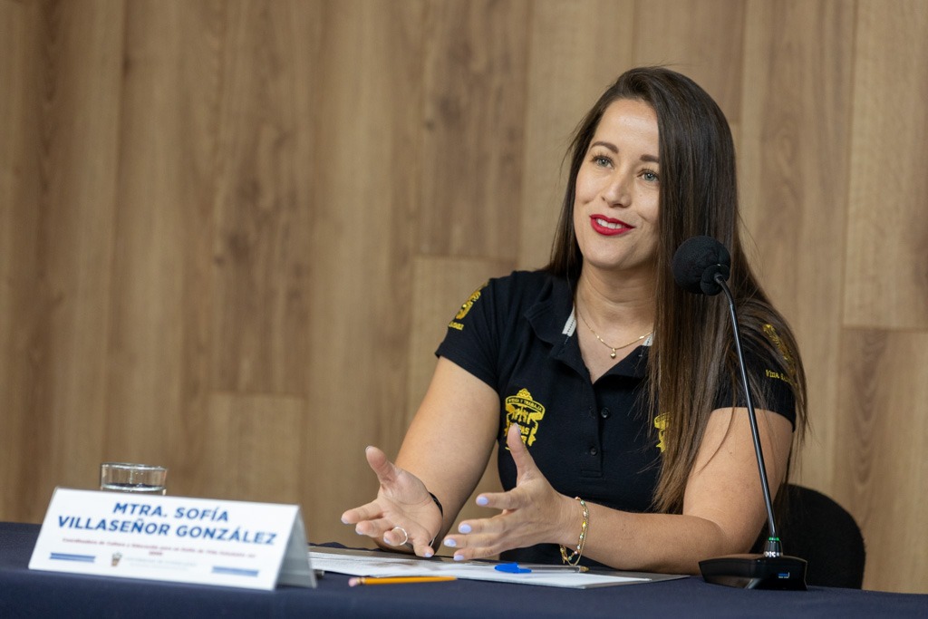 coordinadora de Cultura y Educación para un Estilo de Vida Saludable del Sistema, maestra Sofía Villaseñor sentada en uso de la voz en rueda de prensa