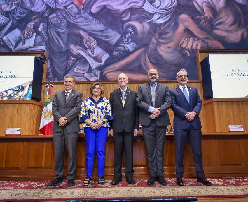 Autoridades del evento de pie en presidium en auditorio