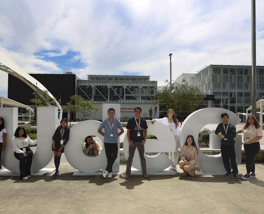 Grupo de alumnos de u d g posan entre letras ante la cámara en exterior