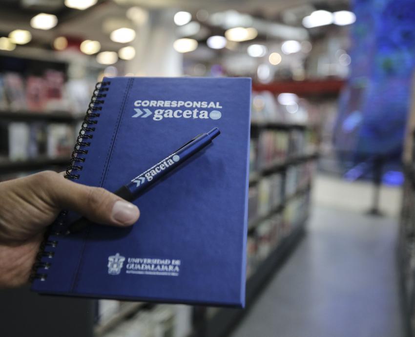 libreta con pasta en color azul y pluma sobre la misma