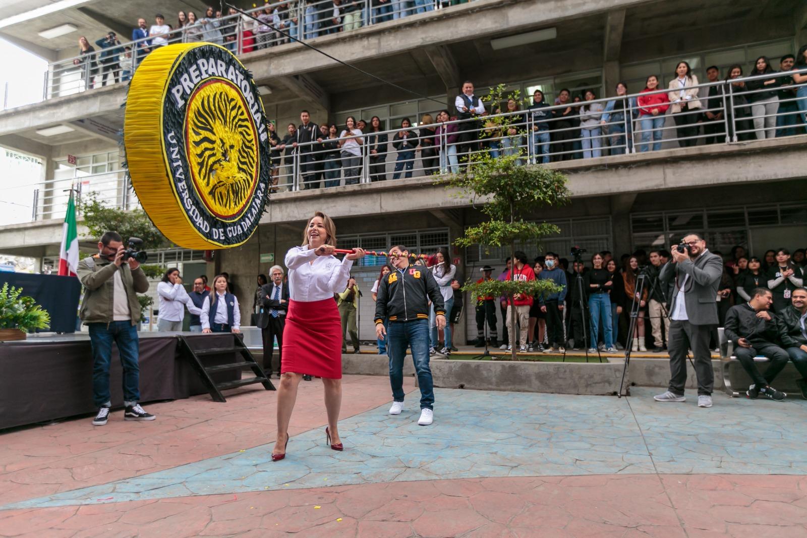 directora del plantel doctora Lucila Rivera Martínez golpeando a la piñata