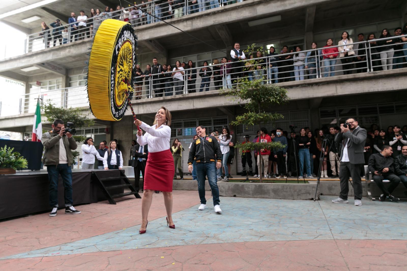 directora del plantel doctora Lucila Rivera Martínez golpeando a la piñata