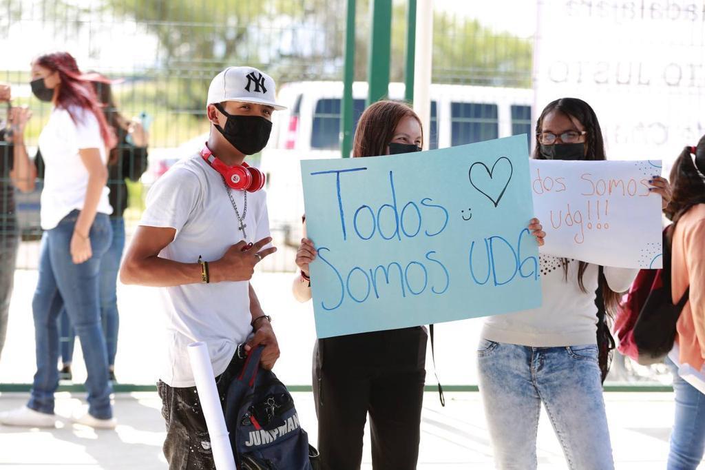 Alumnos con letreros de apoyo