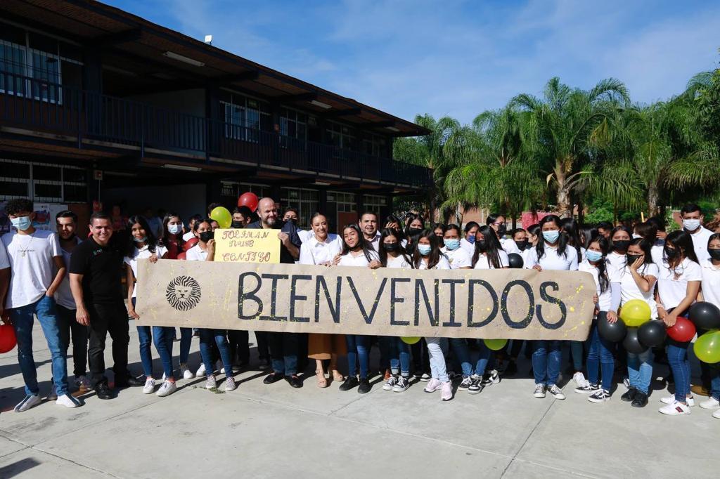 Alumnos con letrero de bienvenida