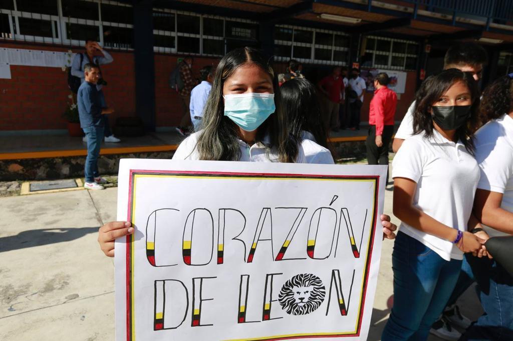 Alumna con letrero con la leyenda corazon de león