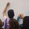 Personas escriben en muro
