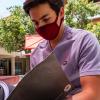 Alumno con cubrebocas lee documentos