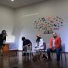 Escritora y autoridades del evento frente a estudiantes en charla