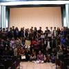 Grupo de participantes y autoridades del evento posando ante la cámara en auditorio