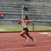 Atleta con estafeta corriendo en pista de atletismo