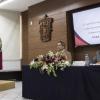Directora en pódium frente a los asistentes al evento