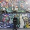 pintor José Pedro Sau Sierralta posa frente al mural que pinto