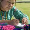 Mujer wixárika escribe en cuaderno 