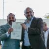 Autoridades del evento sostienen documentos en sus manos
