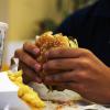 Manos sontiene una hamburguesa